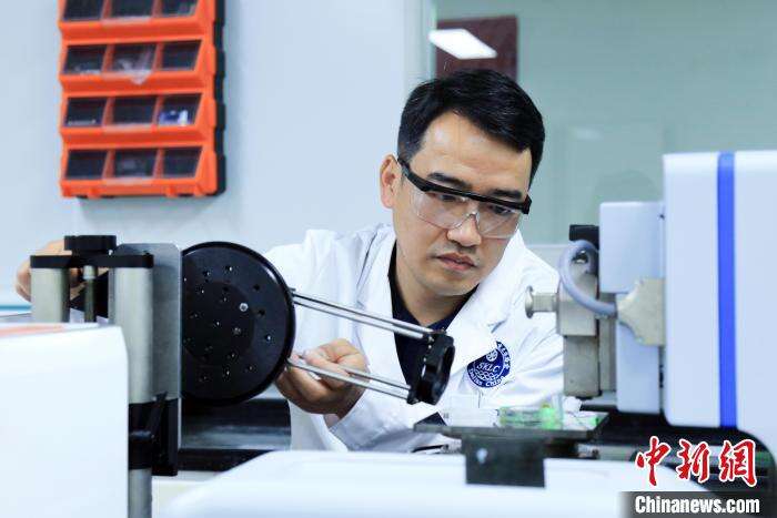 中科院大连化物所范峰滔研究员在调试表面光电压成像仪器。　中科院大连化物所 供图
